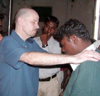 YMG team member praying for man in India