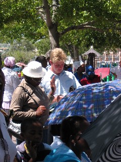 People in the crowd raise their hands and pray to receive Christ